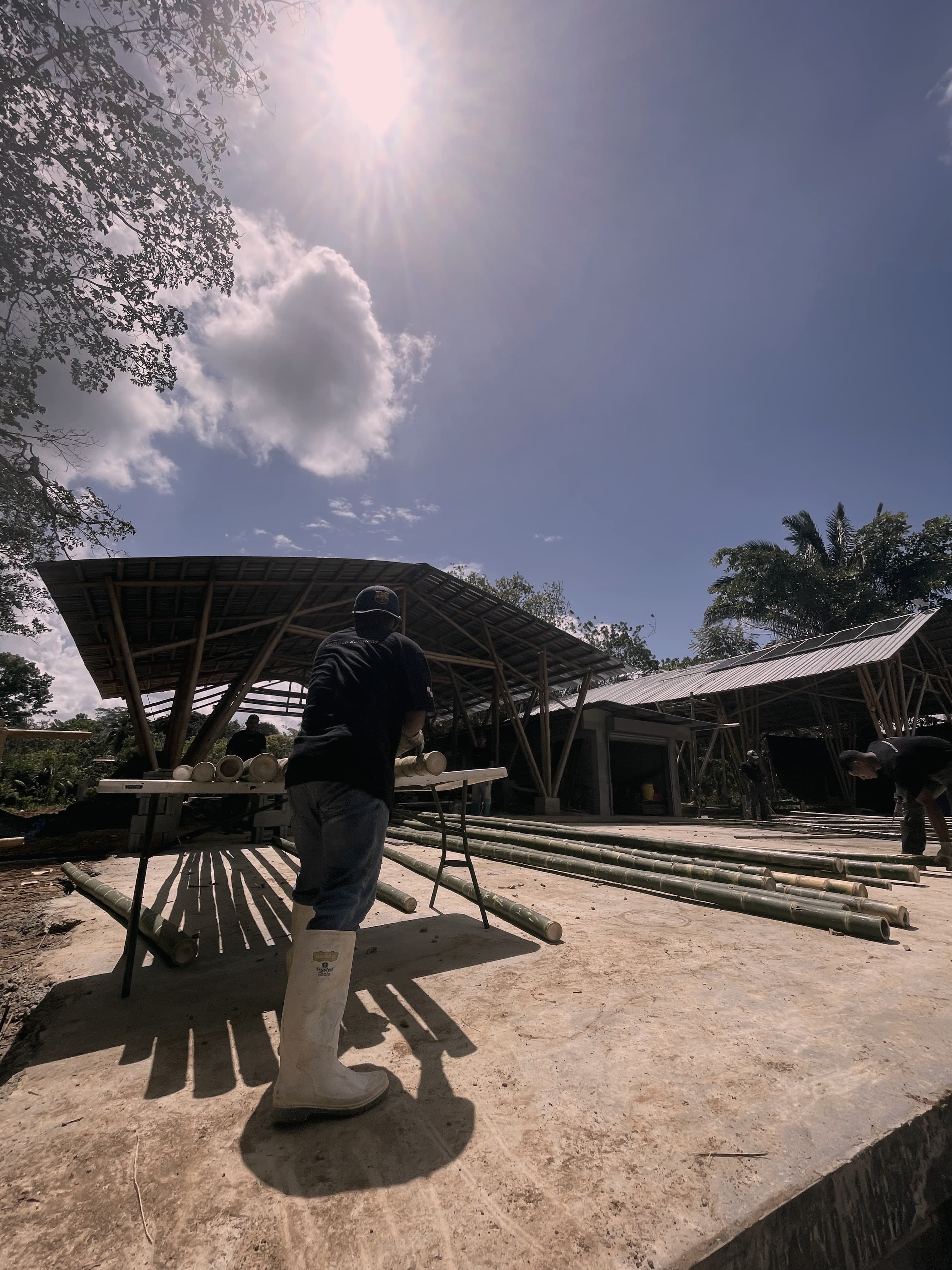 A worker preparing treated guadua poles in the DUAGUA yard